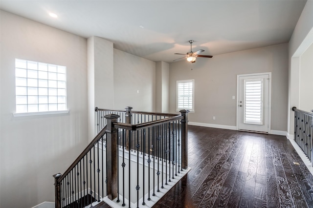 stairway featuring baseboards, ceiling fan, and wood finished floors
