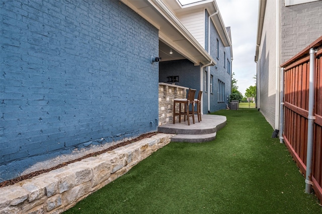 view of yard featuring outdoor dry bar and central AC