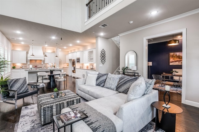 living area with stairs, recessed lighting, visible vents, and dark wood-type flooring