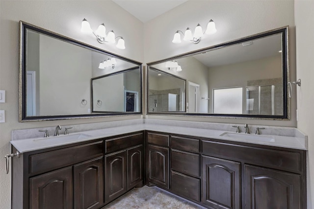 bathroom with double vanity, a shower with door, and a sink