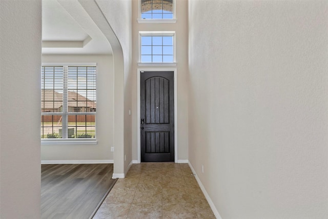 entrance foyer featuring arched walkways and baseboards
