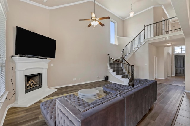 living room featuring high vaulted ceiling, a ceiling fan, stairs, and wood finished floors