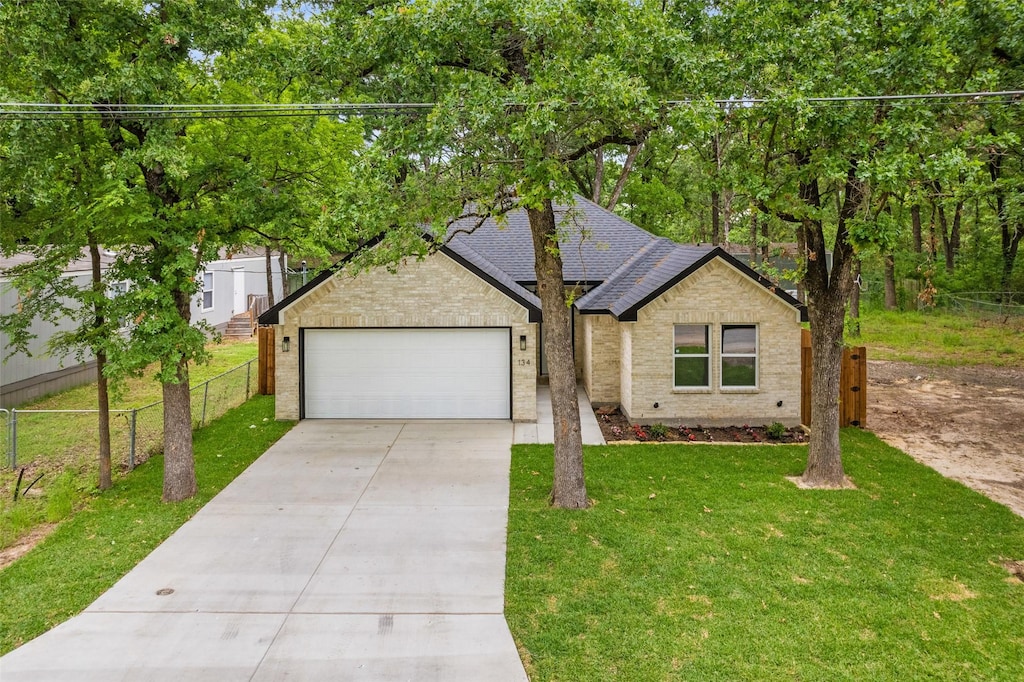 134 Skylark Dr, Mabank, TX 75156 - view of front of property with concrete driveway, brick siding, fence, and a front yard