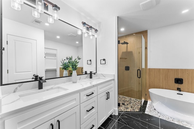 full bathroom with a sink, a freestanding tub, a stall shower, and visible vents
