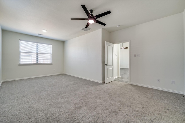 carpeted empty room with a ceiling fan, baseboards, and visible vents