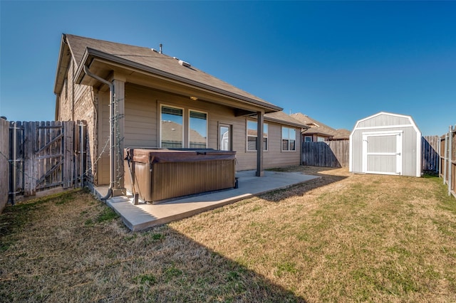 back of property with a fenced backyard, a gate, a hot tub, and a patio area