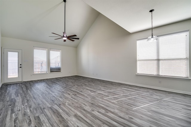 unfurnished living room with vaulted ceiling, baseboards, a ceiling fan, and wood finished floors