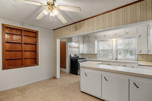 kitchen with light countertops, stainless steel gas range oven, and a textured ceiling