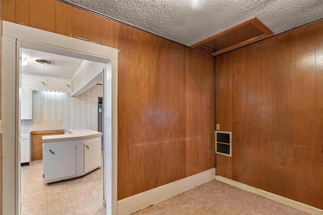 unfurnished room with light floors and a textured ceiling