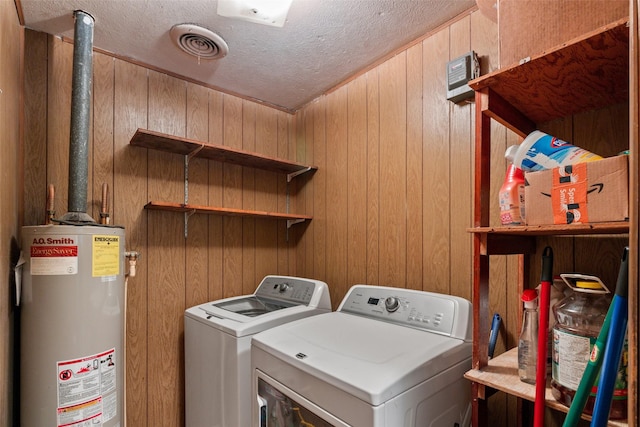 laundry room with gas water heater, washer and clothes dryer, a textured ceiling, and laundry area