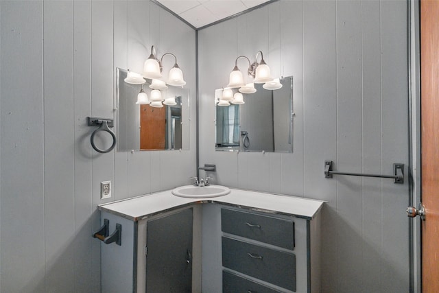 bathroom featuring a decorative wall and vanity