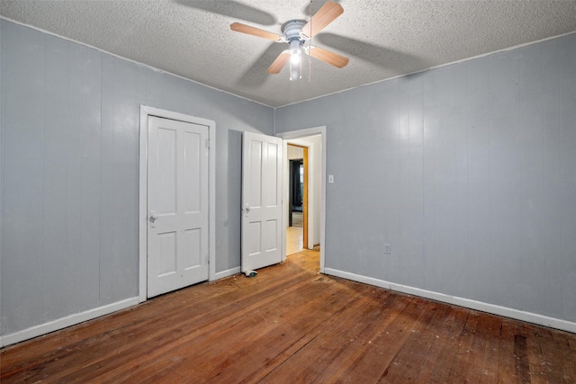 unfurnished bedroom featuring baseboards, a ceiling fan, a textured ceiling, and hardwood / wood-style flooring