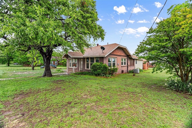 rear view of house featuring a yard and cooling unit