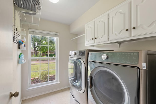 clothes washing area featuring baseboards, cabinet space, light tile patterned floors, and washing machine and dryer