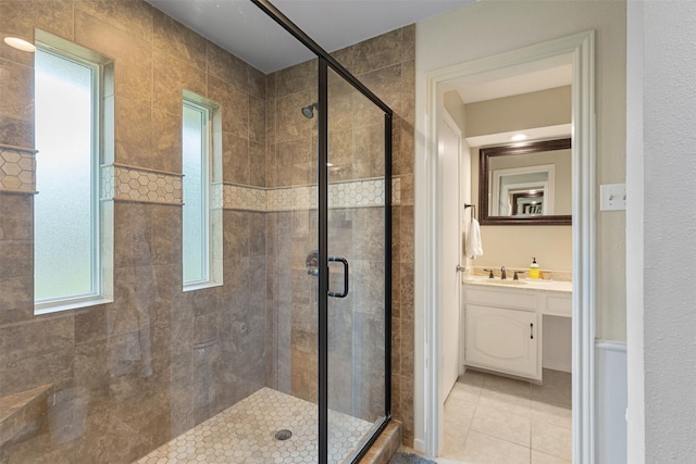 bathroom featuring tile patterned flooring, vanity, and a shower stall