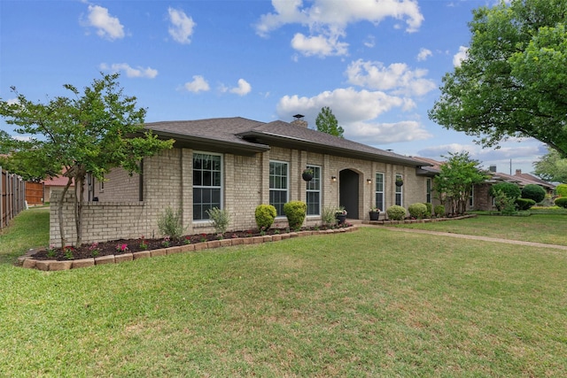 single story home with brick siding, fence, and a front yard