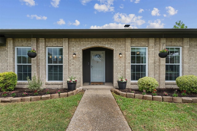 entrance to property featuring brick siding
