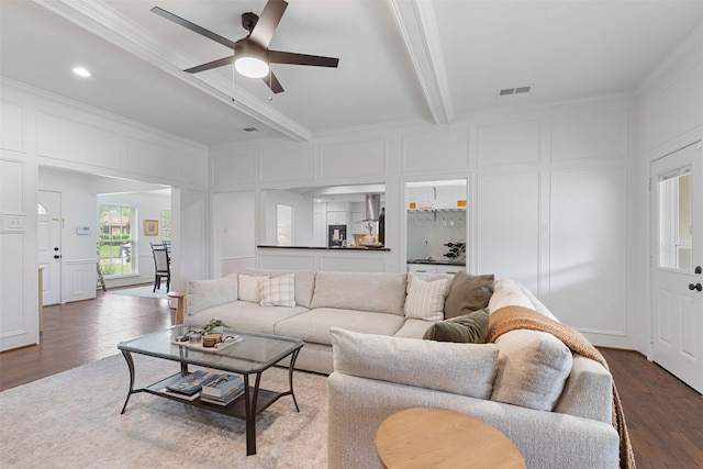 living area featuring visible vents, dark wood-style floors, and a decorative wall