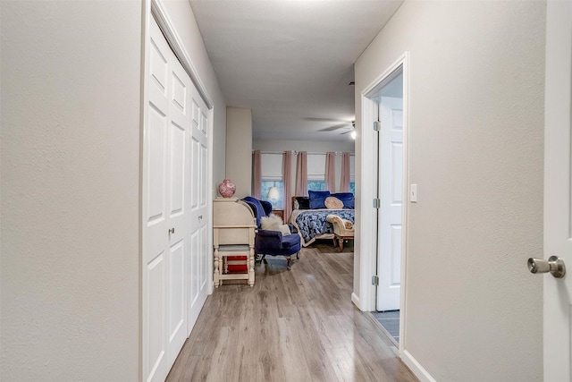 hall with baseboards and light wood-style floors