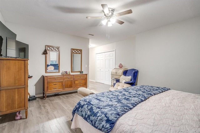 bedroom featuring visible vents, a closet, baseboards, ceiling fan, and light wood-type flooring