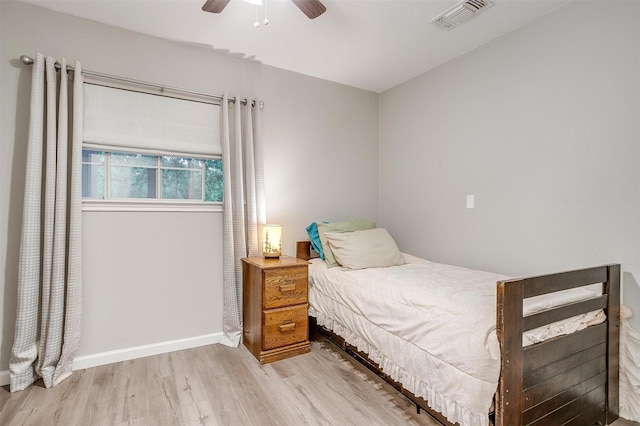bedroom featuring ceiling fan, baseboards, visible vents, and wood finished floors