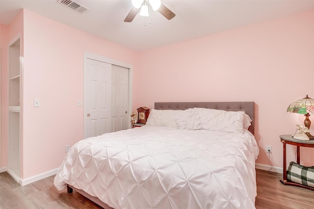 bedroom with a ceiling fan, visible vents, light wood-type flooring, baseboards, and a closet