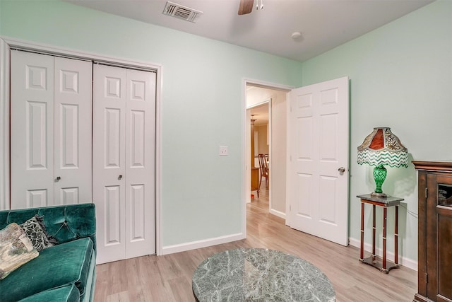 sitting room featuring a ceiling fan, baseboards, visible vents, and light wood-style floors