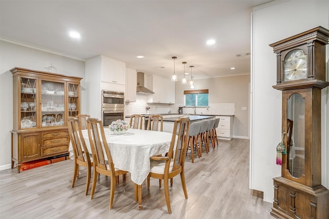dining space with crown molding, recessed lighting, light wood finished floors, and baseboards