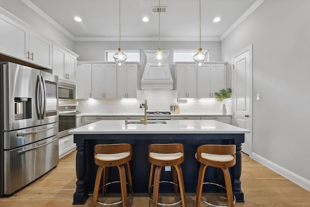 kitchen featuring light countertops, stainless steel appliances, custom range hood, backsplash, and visible vents