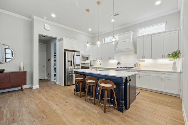 kitchen featuring a breakfast bar area, visible vents, custom range hood, light countertops, and stainless steel appliances