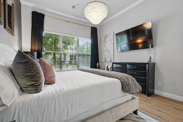bedroom featuring visible vents, crown molding, an inviting chandelier, wood finished floors, and baseboards