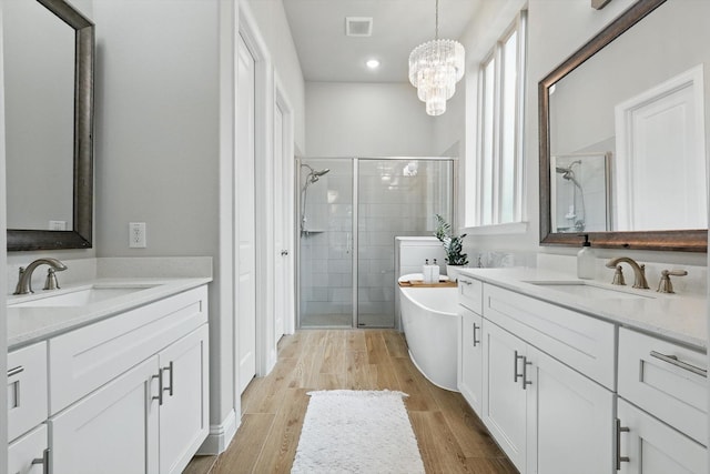 bathroom featuring a soaking tub, a sink, and a stall shower