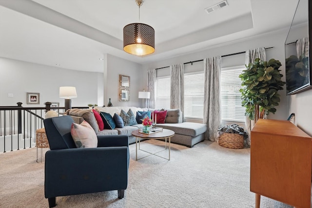 carpeted living room featuring visible vents and a raised ceiling