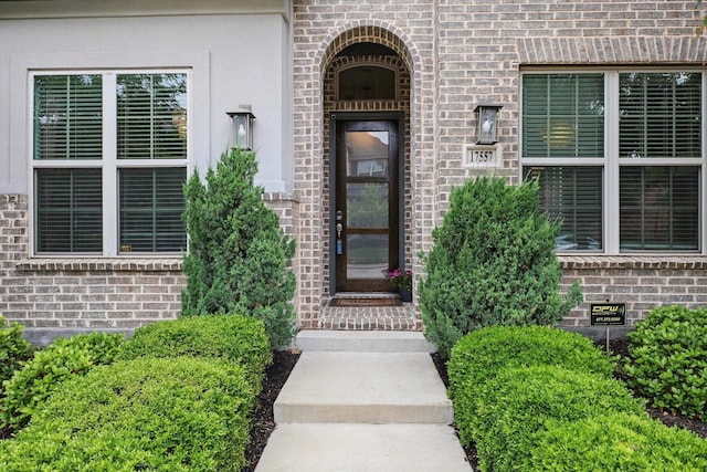 doorway to property with brick siding