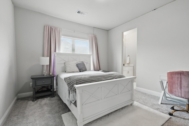 carpeted bedroom featuring baseboards, ensuite bath, and visible vents