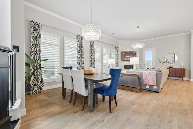 dining area with an inviting chandelier, light wood-style floors, and crown molding