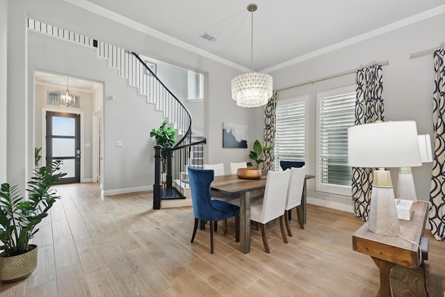 dining area featuring an inviting chandelier, ornamental molding, light wood finished floors, and baseboards