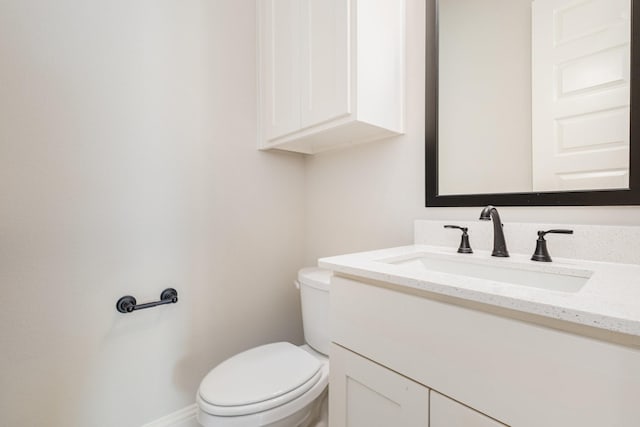bathroom with vanity, baseboards, and toilet