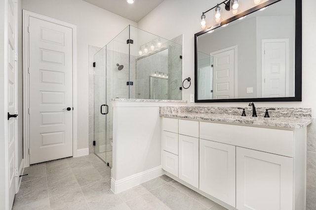 bathroom featuring baseboards, a shower stall, and vanity