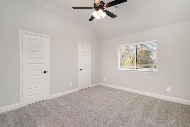 unfurnished bedroom with visible vents, carpet floors, lofted ceiling, baseboards, and a ceiling fan