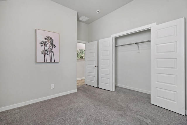 unfurnished bedroom featuring baseboards, carpet, and a closet