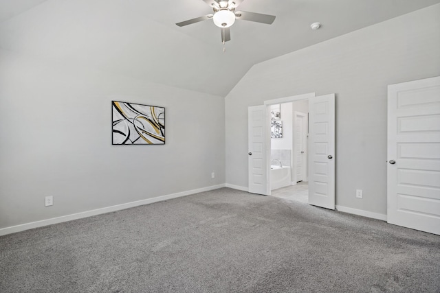 unfurnished bedroom featuring baseboards, carpet, vaulted ceiling, and ensuite bath