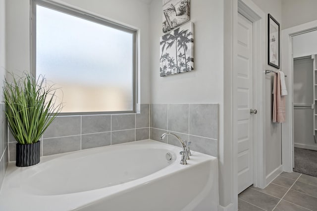 bathroom featuring tile patterned flooring, plenty of natural light, and a bath