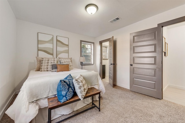 bedroom featuring baseboards, light colored carpet, and visible vents
