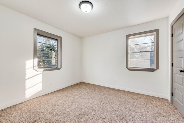 carpeted empty room with baseboards