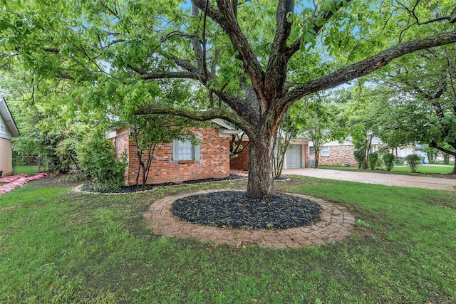 view of front of house with a garage, a front yard, driveway, and brick siding