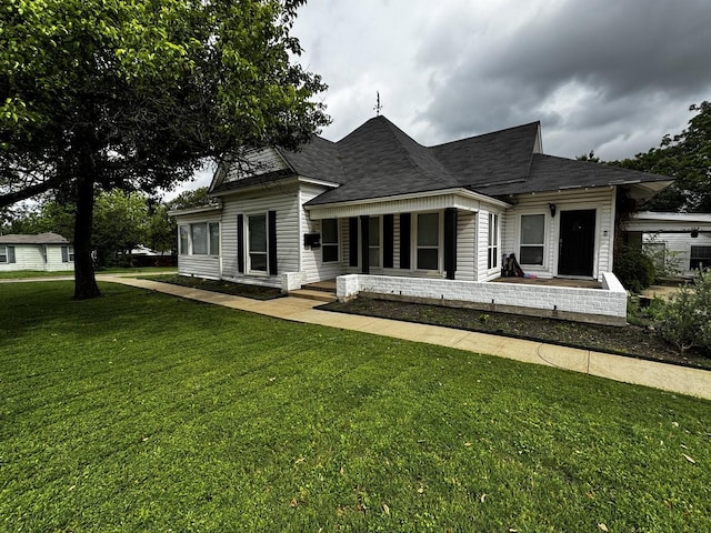 322 Hill St, Grand Prairie, TX 75050 - view of front of house with a shingled roof, a porch, and a front lawn