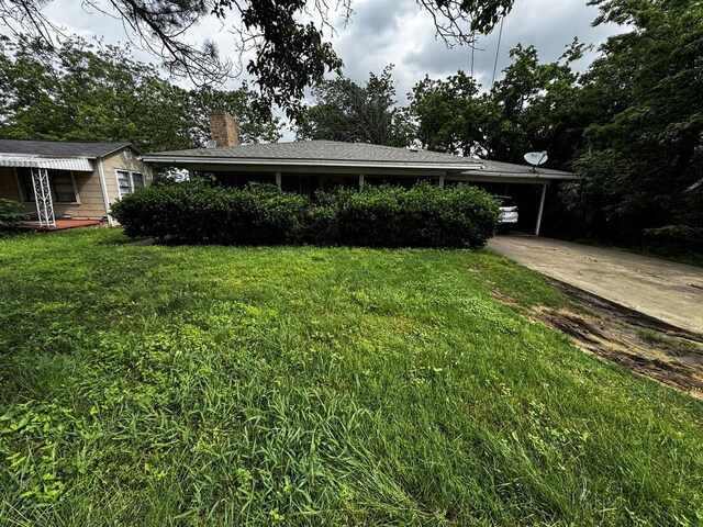 322 Hill St, Grand Prairie, TX 75050 - view of front facade with concrete driveway, an attached carport, a chimney, and a front lawn