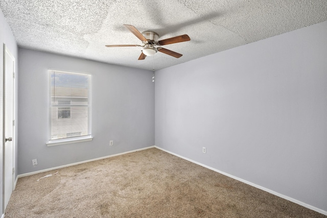 spare room with baseboards, ceiling fan, carpet, and a textured ceiling
