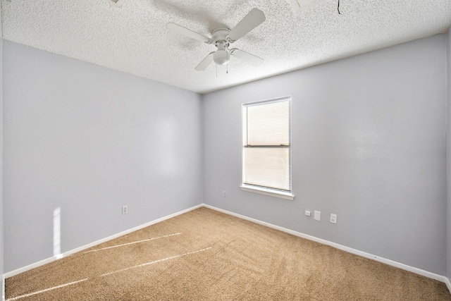 carpeted spare room featuring baseboards, a ceiling fan, and a textured ceiling